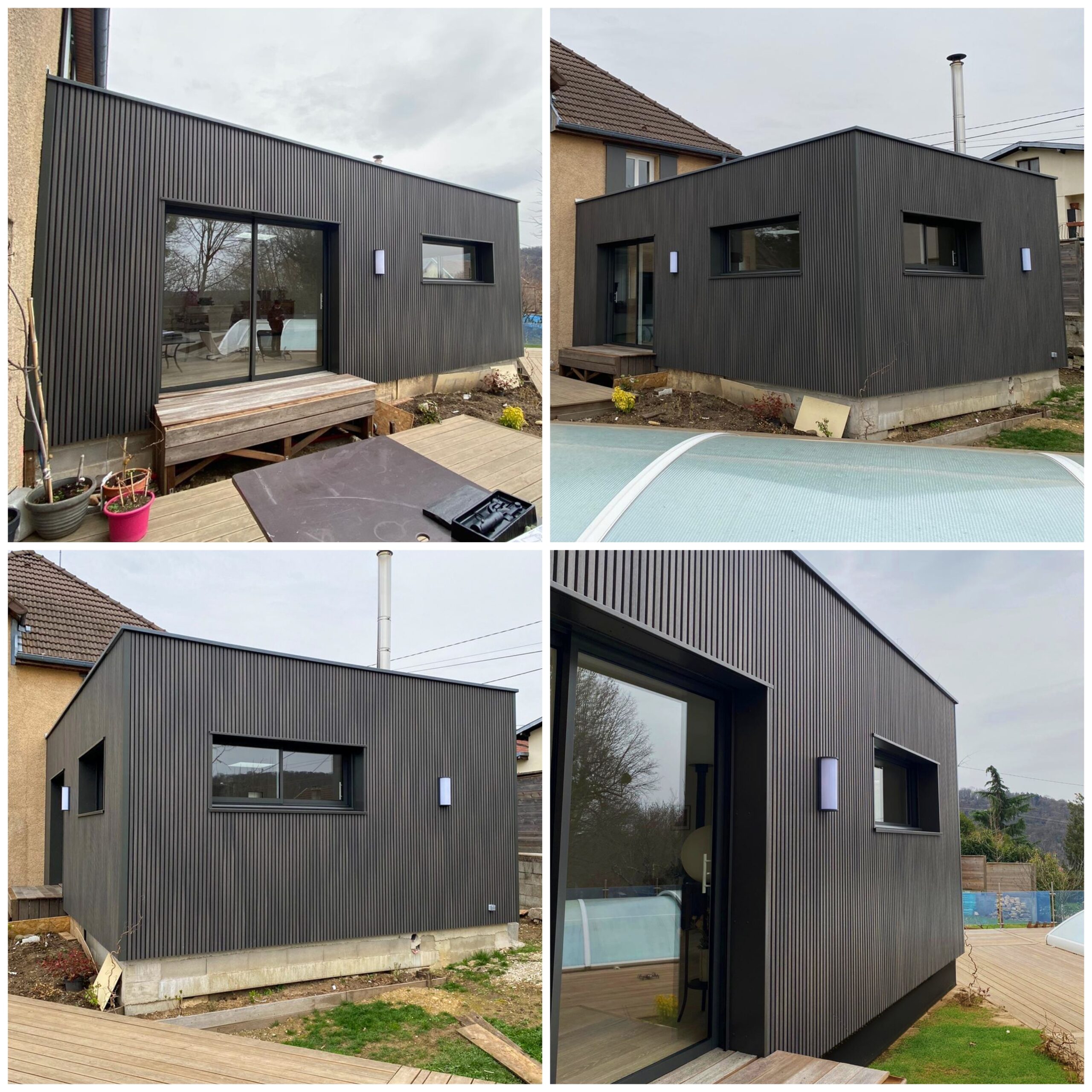 Extension de maison moderne en ossature bois avec bardage composite Fiberdeck gris foncé, toit plat végétalisé, grandes baies vitrées et intégrée à un environnement de jardin avec piscine.