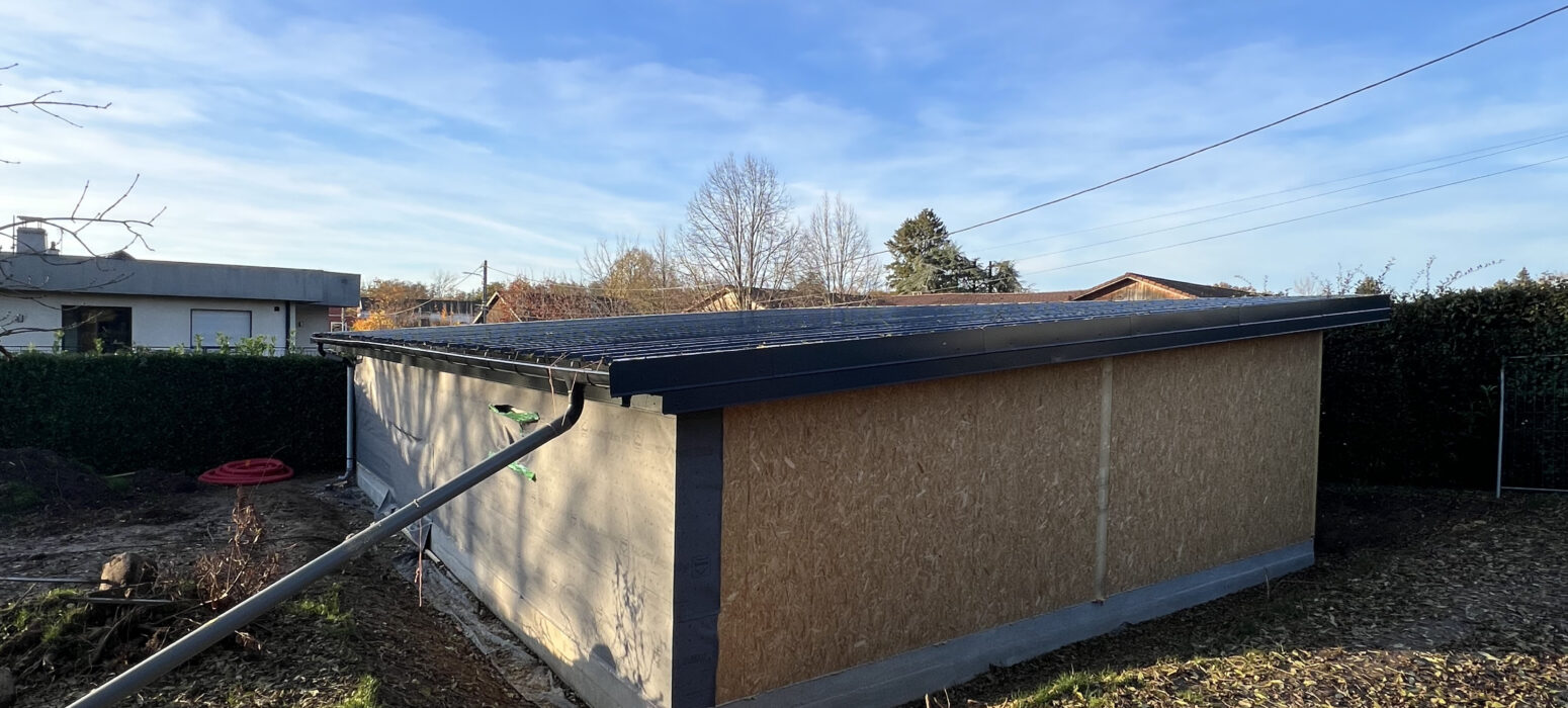 Vue arrière garage ossature bois toit plat en panneaux OSB avec étanchéité en cours